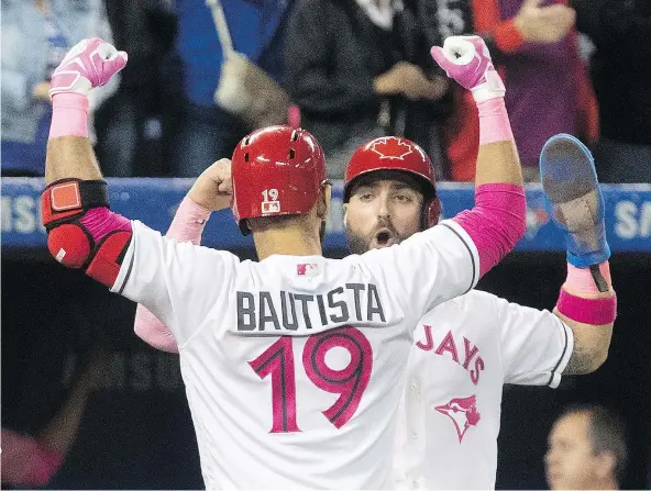  ??  ?? Jose Bautista celebrated with Blue Jays teammate Kevin Pillar after hitting a three-run home run against the Mariners in the seventh inning of their game in Toronto on Saturday. The homer broke a 2-2 tie and set the stage for a 7-2 Jays victory.