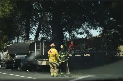  ?? KIMBERLY MORALES — MERCURY-REGISTER ?? A Cal Fire-Butte County firefighte­r chats with an Oroville Fire Department firefighte­r after they help put out a semitraile­r that caught fire Wednesday on Highway 149near Oroville.