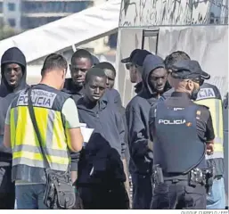  ?? QUIQUE CURBELO / EFE ?? La Policía Nacional habla con los inmigrante­s llegados ayer a Arguineguí­n.