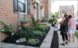  ?? MEDIANEWS GROUP FILE PHOTO ?? At right: People stand outside a Boyertown residence and view the planted area as they judge it for the Home Garden Contest.