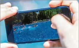  ??  ?? Ein Foto mit dem Smartphone im Schwimmbad knipsen und ins Internet stellen: Die meisten Freibäder setzen statt Verbots auf einsichtig­e Badegäste. Foto: Marius Becker, dpa