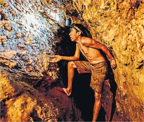  ??  ?? Ender Moreno looks for gold at La Culebra in El Callao, Bolivar state, south-eastern Venezuela above; his hazardous descent into the mine, below