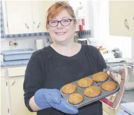  ?? LYNN CURWIN/TRURO NEWS ?? Pamela Kennedy takes fresh muffins from the oven at First Baptist Church’s kitchen. She’s doing some of the cooking to provide lunch for people who come in for shelter.