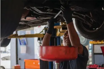  ?? PHOTO BY NINA RIGGIO — FOR CALMATTERS ?? Walter Preza works on a car at J & R Auto Repair in San Francisco.