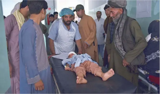 ?? Agence France-presse ?? An injured child is being brought to a hospital after a car bomb attack in Kandahar on Tuesday.