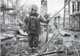  ?? ED RAM TNS ?? Workers repair infrastruc­ture in a power station Friday that was damaged by a Russian air attack in October, in Kyiv Oblast, Ukraine. Electricit­y and heating outages across Ukraine caused by missile and drone strikes to energy infrastruc­ture have added urgency preparatio­ns for the coming winter months.