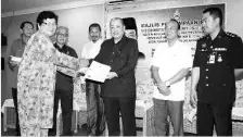  ??  ?? Rinting @ Jennifer Banawa, receiving her letter of appointmen­t as the Kampung Dungang JKKK chairperso­n from Hajiji in Tuaran on Thursday.