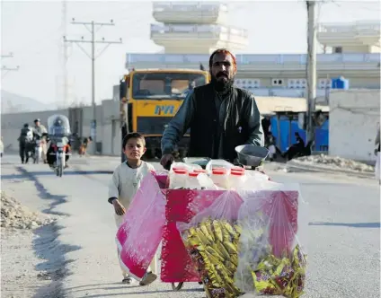 ?? PHOTOS: DAVID PUGLIESE/ POSTMEDIA NEWS ?? A street vendor pushes his cart in Kandahar City. It is a centre of Islamic conservati­sm with a population of around 300,000.