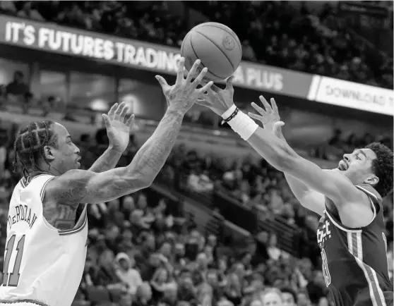  ?? CHARLES REX ARBOGAST/AP ?? Bulls forward DeMar DeRozan, who had 13 points and six assists, battles with Wizards guard Jordan Poole for possession Saturday night at the United Center.