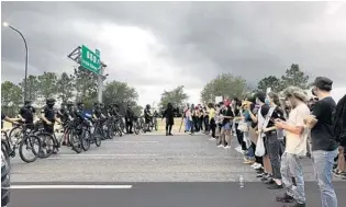  ?? MONIVETTE CORDEIRO/ORLANDO SENTINEL ?? Protesters and police face off Saturday on State Road 408 during protests over the killing of George
Floyd.