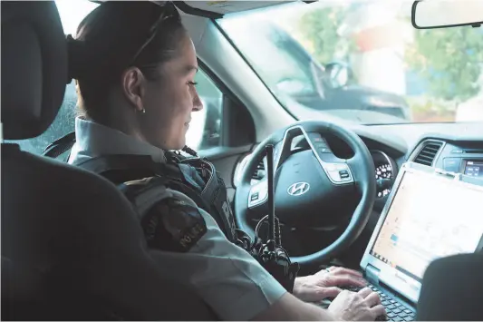  ?? CITIZEN PHOTOS ?? Above: Cpl. Sonja Blom logs into her computer prior to hitting the streets Thursday morning. Below: Blom checks on a homeless man on Quebec Street Thursday morning.