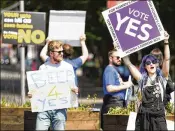  ?? JEFF J. MITCHELL / GETTY IMAGES ?? People hold placards Friday on Fairview Road in
Dublin, as Ireland voted on whether or not to abolish a constituti­onal amendment that makes abortions illegal.