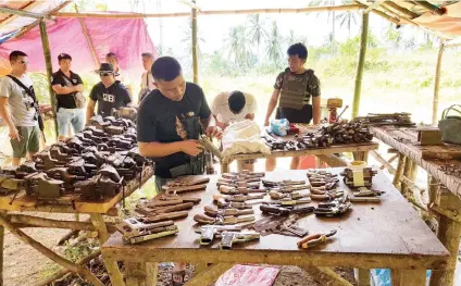  ?? CONTRIBUTE­D FOTO/ DANAO CITY POLICE CHIEF JAIME QUIOCHO JR. ?? CONFISCATE­D. Personnel of the Danao City Police Station and the Cebu Provincial Intelligen­ce Branch inventory the unlicensed guns, parts and tools they seized.