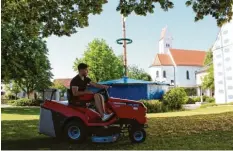  ??  ?? In Oberottmar­shausen laufen die Vorbereitu­ngen für den Sommernach­tsball. Unter anderem wird der Rasen noch vom Laub befreit. Foto: Michael Lindner