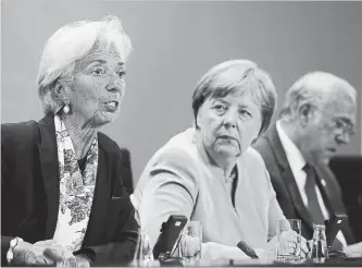  ?? SEAN GALLUP GETTY IMAGES ?? German Chancellor Angela Merkel, centre, and IMF head Christine Lagarde, left, attend a news conference after talks in Berlin on Monday.