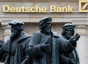  ?? (Kai Pfaffenbac­h/Reuters) ?? STATUES are pictured next to the logo of Germany’s Deutsche Bank in Frankfurt last September.