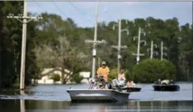  ?? MATT BORN — THE STAR-NEWS VIA AP ?? Area residents ride down N.C. Highway 53 that is flooded from the Northeast Cape Fear River in Burgaw, N.C., Wednesday. The river had severe flooding due to the rains from Hurricane Florence.