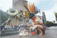  ??  ?? Rinden homenaje. Un danzante prehispáni­co encendió una de tantas velas para conmemorar la represión en la Plaza de Tres Culturas.