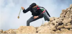  ?? Photo / AP ?? A Palestinia­n hurls stones during a protest against Israeli settlement­s. Under Prime Minister Benjamin Netanyahu, Israel approved or advanced constructi­on of more than 12,000 settlement homes in 2020.