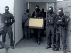  ?? FELIX HACKENBRUC­H/THE ASSOCIATED PRESS ?? Police carry a box outside of a residentia­l building in Berlin, Germany, on Tuesday in raids targeting sites connected to mosque frequented by Anis Amri, who killed 12 people at a market in December.