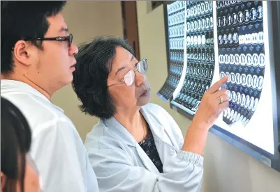  ?? PHOTOS PROVIDED TO CHINA DAILY ?? Liao Meilin (right) reads CT scans with colleagues at the Shanghai Chest Hospital.