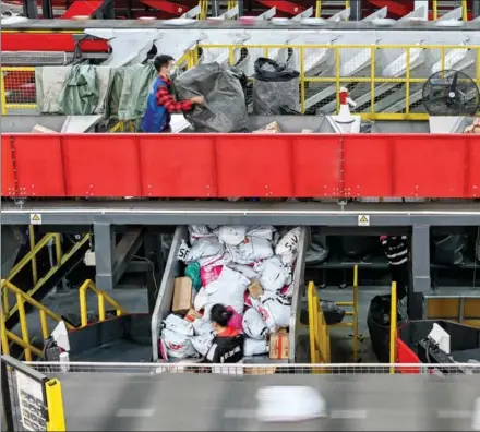  ?? ?? Workers sort parcels at a Shunfeng Freight Co delivery center in Guangzhou, Guangdong province, on Nov 11.