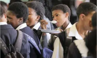  ?? BRENTON GEACH ?? THE government is spending more than R8 billion annually on the school feeding scheme, but regardless of its intended policy of using spending to overcome the triple challenge of poverty, unemployme­nt and inequality, this appears not to be happening. School feeding at Windermere high school in Kensington; here Thandokazi Msali, a Grade 8 pupil enjoys her meal. |
