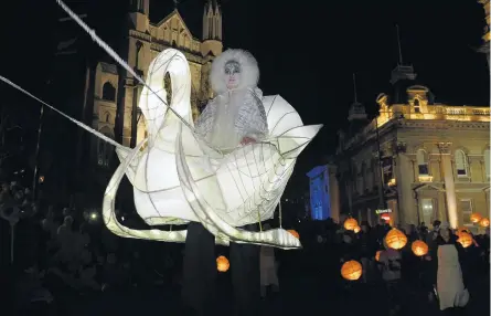  ?? PHOTOS: STEPHEN JAQUIERY ?? Snow sleigh . . . Stilt walker Mary Cocker, of Dunedin, appears to be floating in midair in a swanthemed carriage during the Dunedin Midwinter Carnival in the Octagon on Saturday night.