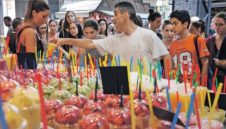  ?? MARC ARIAS ?? La nueva esencia de la Boqueria. La venta de zumos de fruta a turistas se ha convertido en una de las imágenes más repetidas todo el año, y sobre todo en verano, en el mercado