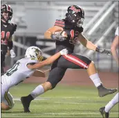  ?? Dan Watson/The Signal ?? Hart High’s Dylan Vradenburg (12) drags Canyon High defender Dylan Roof (20) as he scoops up a Canyon fumble to score Hart’s fourth touchdown during the second quarter at Valencia on Friday.