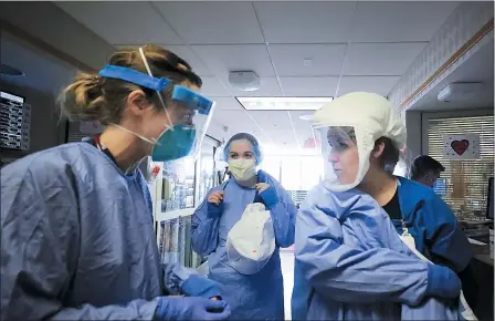  ?? JOHN HART — WISCONSIN STATE JOURNAL VIA AP ?? Medical staff attending to patients with COVID-19 wear protective equipment in a unit dedicated to treatment of the coronaviru­s at UW Health in Madison, Wis., on Nov. 5. Conditions inside the nation’s hospitals are deteriorat­ing by the day as the coronaviru­s rages through the country.