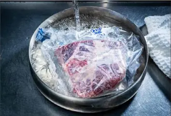  ?? Scott Suchman/Washington Post ?? A cold-water bath is a recommende­d strategy for thawing meat.