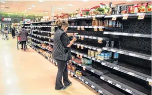  ??  ?? An employee takes inventory at a grocery store amid coronaviru­s fears spreading, in Toronto on March 13.