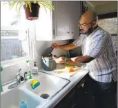  ?? NELVIN C. CEPEDA U-T ?? Victor Sanchez, at his home in National City, places his food waste in a special countertop food container.