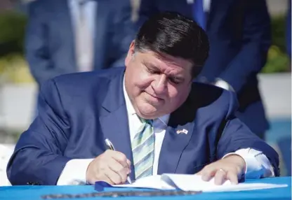  ?? ANTHONY VAZQUEZ/SUN-TIMES FILE ?? Gov. J.B. Pritzker signs the state’s Climate and Equitable Jobs Act on Sept. 15. Pritzker on Sept. 24 signed off on new electoral maps the Legislatur­e will use for the next decade, despite concerns from certain groups.