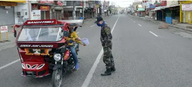  ??  ?? A LAW ENFORCER of the Toril Police Station checks the papers of the driver to make sure that he is not violating the clustering and quarantine protocols. The use of the food and medicine pass is prohibited on Sundays. BING GONZALES