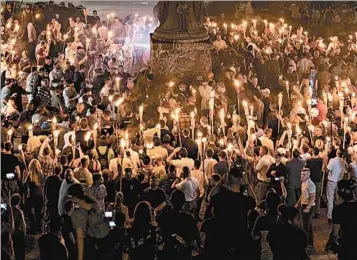  ?? EVELYN HOCKSTEIN/FOR THE WASHINGTON POST ?? Hundreds of neo-Nazis and white supremacis­ts carry torches Aug. 11 across the University of Virginia campus.