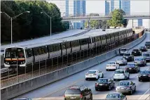  ?? BEN GRAY / BGRAY@AJC.COM ?? A MARTA train (above) makes its way north past Ga. 400 traffic near Sandy Springs on a typical afternoon rush hour.