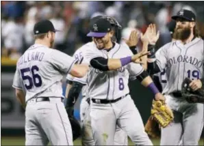  ?? THE ASSOCIATED PRESS ?? The Rockies’ Gerardo Parra (8) celebrates with Greg Holland (56), Charlie Blackmon (19) and other teammates after the team’s 7-6 victory against the Arizona Diamondbac­ks on Saturday. In his first season back following elbow reconstruc­tive surgery,...