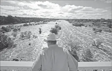  ?? Jay Janner/Austin American-Statesman via AP ?? Tex Toler watches the Llano River rise Friday in Llano, Texas, after another round of heavy rain. Officials are closely monitoring the levels of rivers in Texas engorged by heavy rain last weekend.