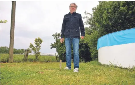  ?? FOTO: KAISER ?? Edgar Kohlhaas in seinem Garten. Er steht neben einem kleinen Pfahl, der markiert, wo der Weg für den Nachbarn verlaufen würde.