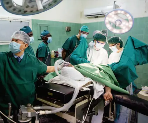  ??  ?? Chinese doctors perform surgery on a Zambian patient in the operating room at the China-zambia Friendship Hospital.