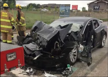  ?? The Associated Press file ?? A collision involving a Tesla Model S sedan with a Fire Department mechanic truck stopped at a red light is seen May 11 in South Jordan, Utah. The Tesla that crashed while in Autopilot mode accelerate­d in the seconds before it smashed into a firetruck.