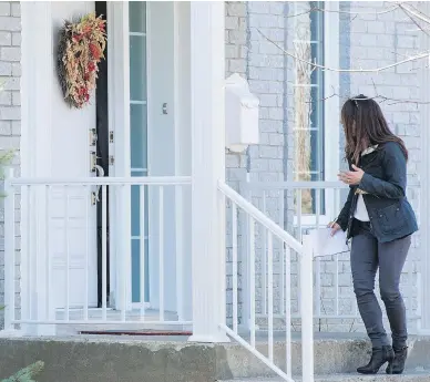  ?? RYAN REMIORZ / THE CANADIAN PRESS ?? Karla Homolka yells at a reporter through a crack in the door, Wednesday in Châteaugua­y, Que. Residents were stunned to learn this week that Homolka, 45, resides in the community and her children attend school nearby.