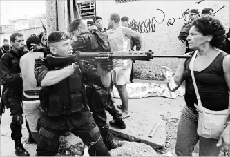  ?? RICARDO MORAES ASSOCIATED PRESS FILE PHOTO ?? Police stop a protest over a shootout involving drug trafficker­s in Rio de Janeiro, Brazil, where the NRA helped kill a referendum on gun sales.