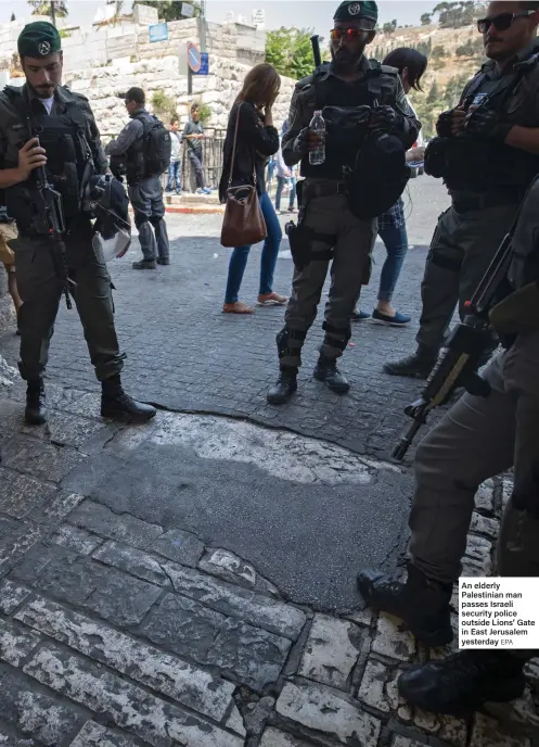  ?? EPA ?? An elderly Palestinia­n man passes Israeli security police outside Lions’ Gate in East Jerusalem yesterday