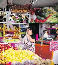  ??  ?? Lourdes Salazar shops for fruit in a store in Temascalci­ngo.