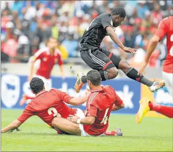  ?? PHOTO: GALLO IMAGES ?? ACROBATIC: Orlando Pirates midfielder Sifiso Myeni avoids a tackle from Al Ahly players during their Caf Champions League match at Orlando Stadium yesterday