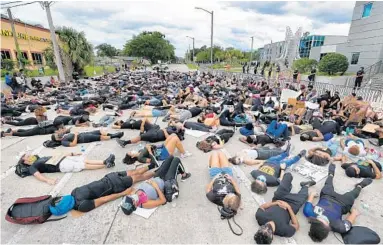  ?? JOE BURBANK/ORLANDO SENTINEL ?? Protesters lie down on South Street in front of the Orlando Police Department on Friday.