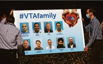  ?? Josie Lepe / Special to the Chronicle ?? VTA employees place a sign with pictures of the shooting victims. Terra said the gunman’s threats were well known among VTA families, including hers, but were not addressed.